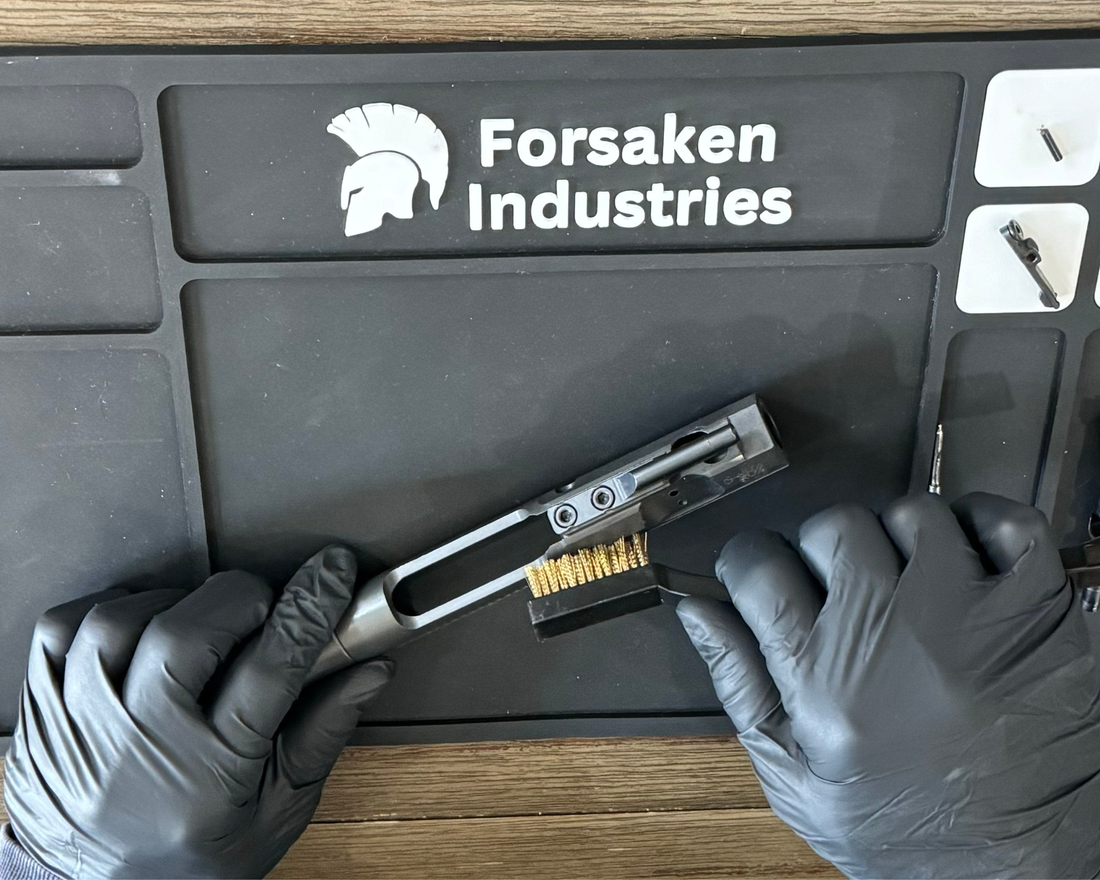 Applying CLP gun cleaner to an AR15 bolt carrier group during firearm cleaning.