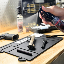 Veteran applying Forsaken CLP 8oz trigger sprayer on handgun parts during cleaning