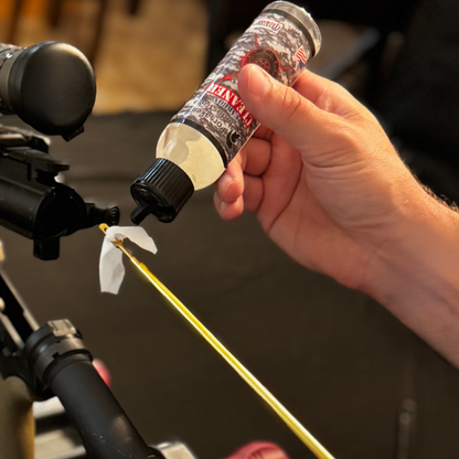 Applying Forsaken Industries Carbon Cleaner 4oz squeeze bottle onto cleaning patch for precision carbon removal inside rifle barrel