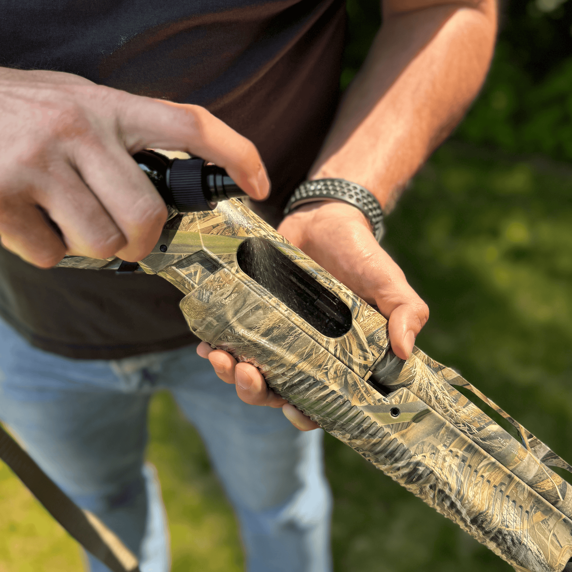Applying Forsaken Industries CLP 4 oz Pump Sprayer to shotgun receiver for cleaning and lubrication